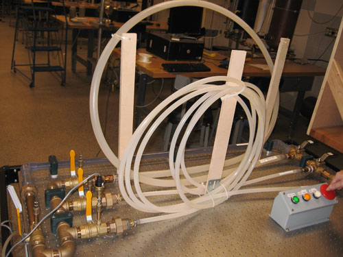 The system contains three pipes in parallel, with different lengths of plastic tubing coiled up in the middle. Each pipe has a selection and terminal valve.