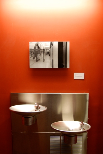 Photograph displayed above water fountains, viewed straight on.