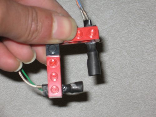 Two LEGO beams make an L, each supporting a diode wrapped in heat-shrink tubing.