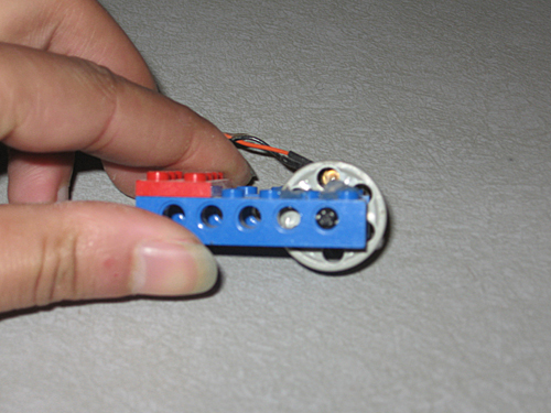A side view of the pulley wheel with the LED visible through the top hole.
