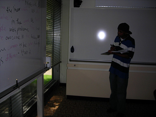 A student stands near the whiteboard and makes an observation.