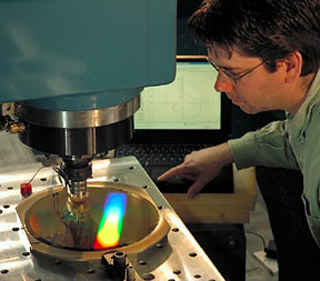 A technician works with a metrology device.
