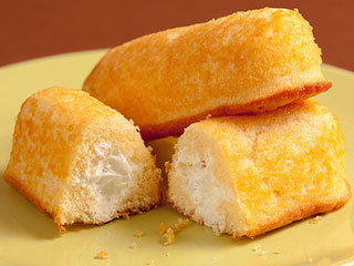 A plate of yellow sponge cakes filled with cream in the center.