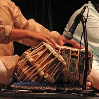 Closeup photo of performance on the tabla, a pair of small single-headed hand drums.