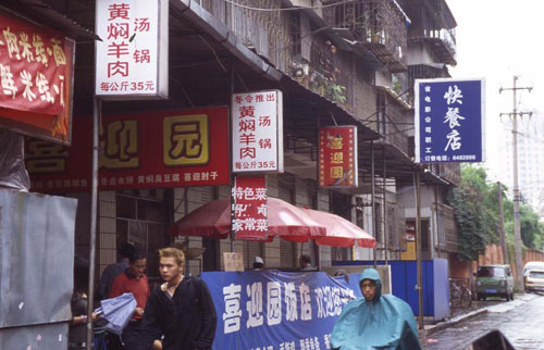 СĹ档[Advertisements for restaurants along a street in Kunming.]