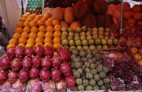 ϵˮ̯ɫ ǻ  [Close up of a fruit stand. The red fruit is fire-dragon-fruit; the fruit in the back is durian.]