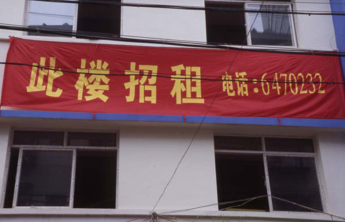 ϵĹ档[Advertisement on the side of an apartment building.]