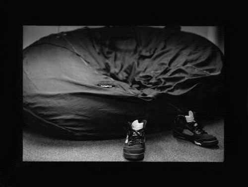 Photograph of shoes and a recently occupied beanbag.