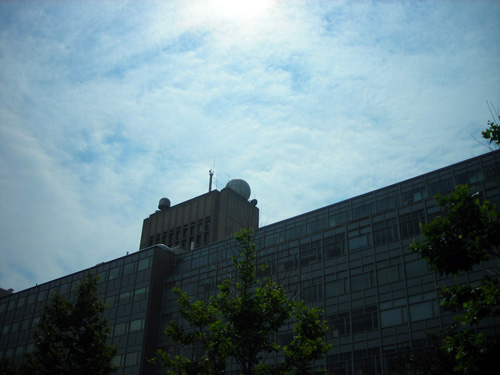 A large sphere sits on top of a tall building.