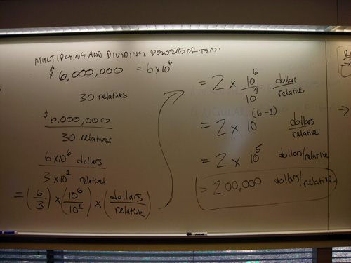 Notes on a whiteboard explain how to multiply and divide by powers of ten.