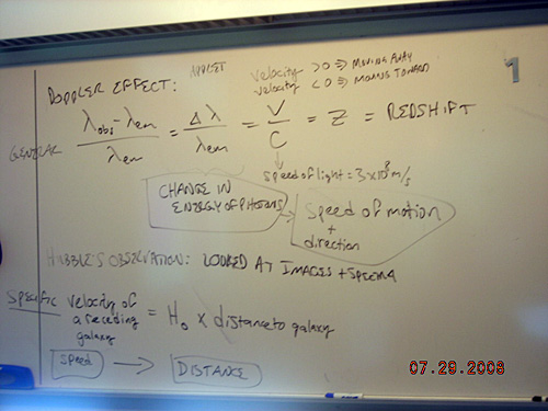 Notes on a whiteboard about Hubble's law.