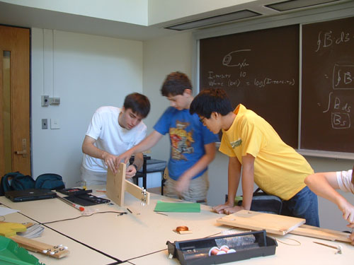 Three students working on one guitar.