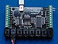One big and one small circuit board placed on a blue surface with attached wires