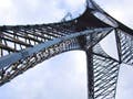 A tall, three-footed tower stretching into blue sky.