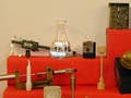 A photo of various equipment- like a caliper, scale, beaker with sample materials like pieces of wood, metal and stone.