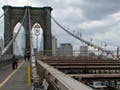 A photo looking down the middle of the pedestrian walkway on the Brooklyn Bridge.