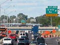 A photo of a traffic jam on a three lane highway.