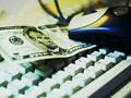 Five dollar bill on a computer keyboard.