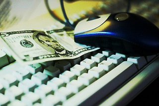 Five dollar bill on a computer keyboard.