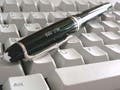 Photograph of pen and computer keyboard.