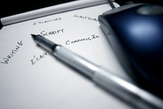 A photo of a pen lying across a writing pad.