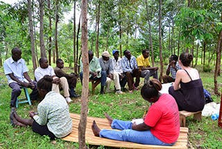 A photo of a group of men and women sitting in a circle in Western Kenya, discussing the affects of climate change on their community.