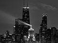 A black and white photo of the Chicago skyline at night.