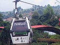 Photo of an informal settlement in Medellin, Colombia with a public library in the background and aerial cable cars above.