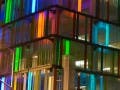 The exterior of a modern, glass-clad parking garage.