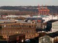 A distant photo of big buildings, warehouses, and cranes.