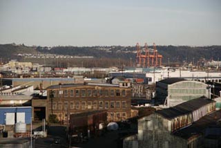 A distant photo of big buildings, warehouses, and cranes.