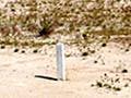 White boundary stones in an arid landscape, marking the boundary between public and private land.