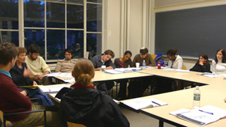 Photograph of instructor and students engaged in class discussion.