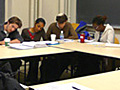 Photograph of instructor and students engaged in class discussion.