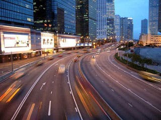 Photograph of a city and highway at night.