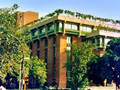 A building at a university that has trees planted on the roof. 