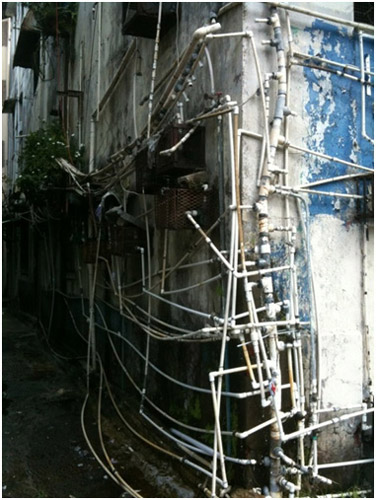 A network of pipes criss-cross the outside of a building.