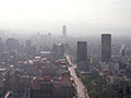 An aerial photo of the Mexico City skyline with haze in the distance.