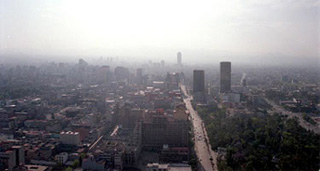 An aerial photo of the Mexico City skyline with haze in the distance.
