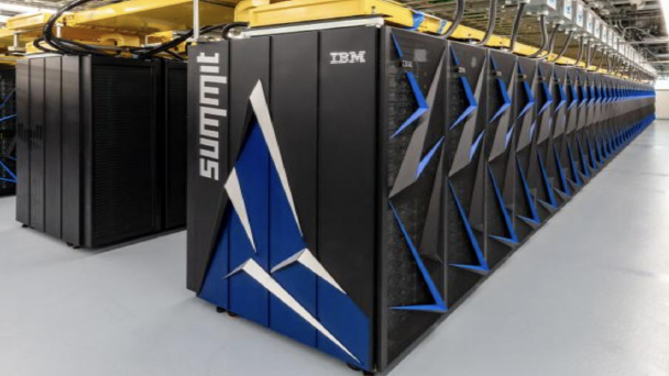 A large warehouse-like room filled with rows of connected electronic modules, with the Summit logo and the IBM logo printed on one end of the first row.