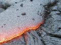 Image of a pillow basalt formation glowing red.