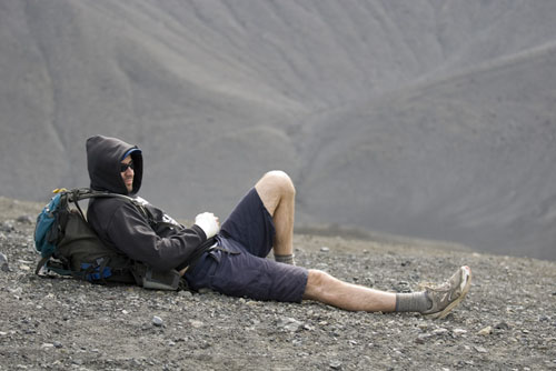 Student relaxing amid barren landscape.