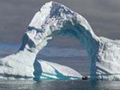 Arch of ice over the Antarctic ocean.