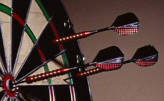 Photograph of darts in a dart board.