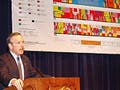 Commerce Secretary Evans presenting in front of a chart of the electromagnetic spectrum.