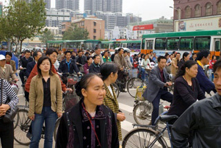 Pedestrians, bicyclists, and buses during rush hour traffic.