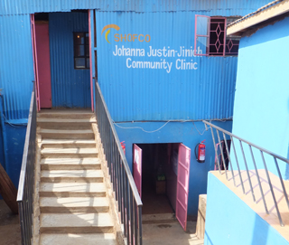 Steps lead up to the entrance of a community health clinic in Kibera, a corrugated metal building painted bright blue.