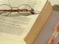 A photo of glass sitting on top of an open book.