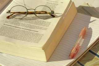 A photo of glass sitting on top of an open book.