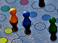 Blue and yellow board game with different colored wooden pieces and dice.